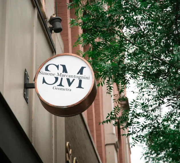 Un cartello rotondo attaccato a un edificio mostra le lettere 